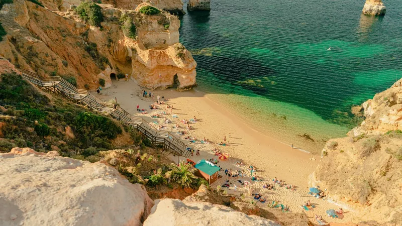 Strand tussen kliffen in de Algarve, luchtfoto met toegang via trappen